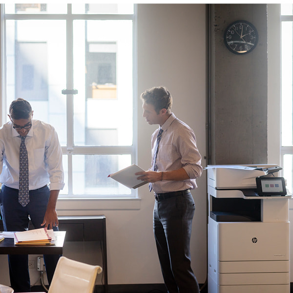 Two men in office and an HP office printer scanner